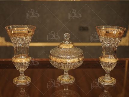 کریستال ۲۴٪ با طلاکاری ۱۲ عیار براق شکلات خوری صاید بزرگ با طراحی لوکس شامل دو گلدان ست هماهنگ قابلیت سفارش تکی یا به صورت مجموعه کامل محصول کشور لحظتانه با برند معتبر بهیماه مناسب سرو شکلات، شیرینی و پذیرایی مجلل گارانتی مادام‌العمر و تضمین اصالت طراحی فاخر و هماهنگ با دیگر اجزای ست کریستال تمام اجزا دارای حکاکی‌های طلایی امیخ سرویس کامل جهازی نیز موجود و قابل سفارش